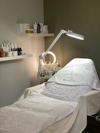 a white bed in a room with a light on it